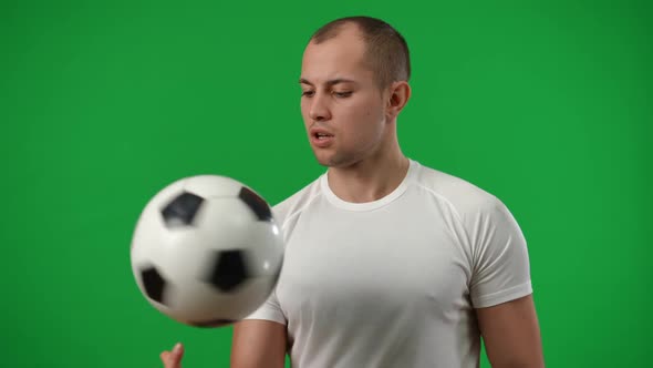 Medium Shot Portrait of Young Caucasian Sportsman Spinning Football Ball on Finger in Slow Motion