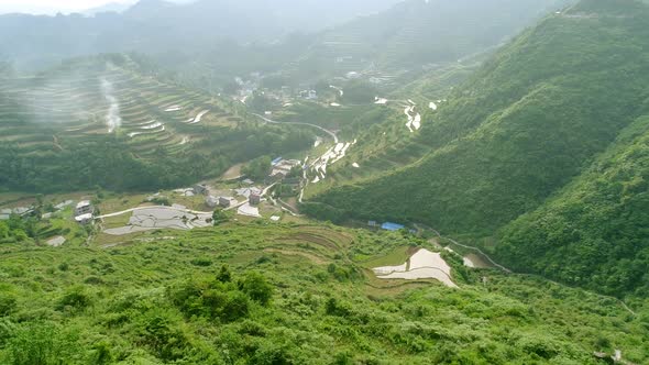 Aerial View of Rural Village Surrounded By Green Terraced Rice Field Farms in South of China