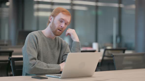 Tired Young Man Taking Nap While Sitting in Office with Laptop