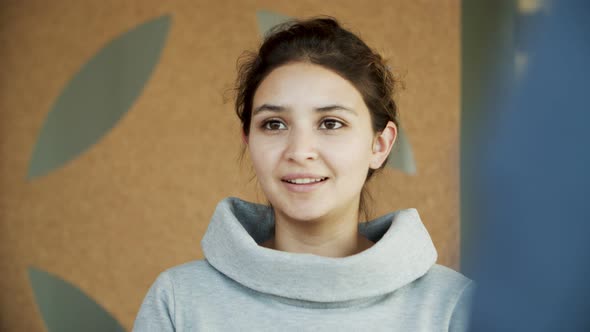 Front View of Smiling Young Woman Talking 