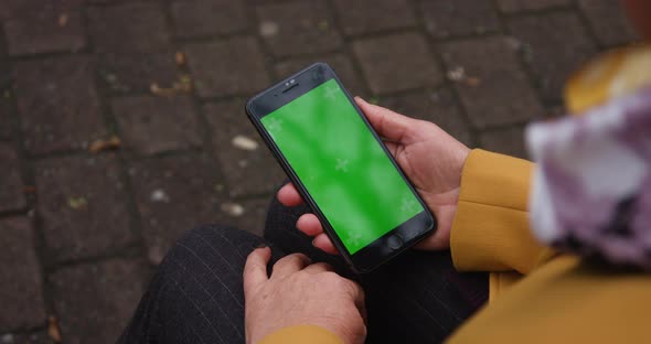 Close Up Hands Woman Holding Phone Vertical Green Screen Busy Street Background Pavement Scrolling