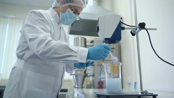 Man Scientist Making Experiment with Mixing Liquid and Powder Spbas