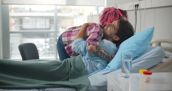 Young Woman Visiting Sick Boyfriend in Hospital Ward