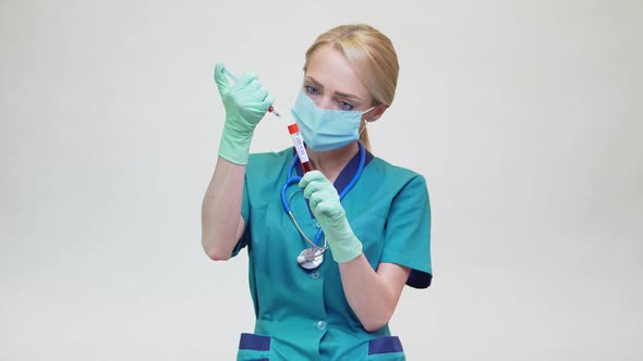 Doctor Nurse Woman Wearing Protective Mask and Latex Gloves - Holding Blood Test Tube and Syringe