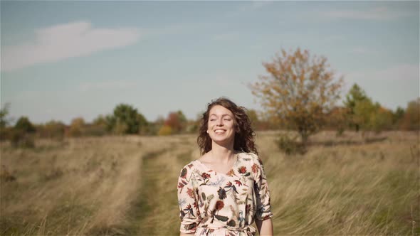 Portrait of Positive Smiling Woman Looking Into Camera at Sunset