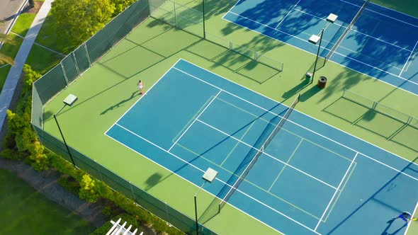  Drone Camera Moves Around a Tennis Court Where There Is an Active Game Match