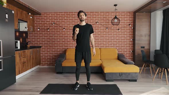 Fit Sporty Man Eating Apple for Light Snack at Livivng Room