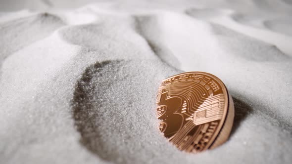 Bitcoin Cryptocurrency Gold Coins Fall on Dry White Sand