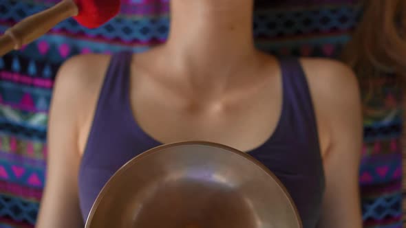 Superslowmotion Shot of a Woman Master of Asian Sacred Medicine Performs Tibetan Bowls Healing