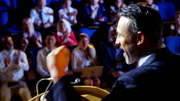 Caucasian businessman speaking in business seminar on stage in auditorium 4k