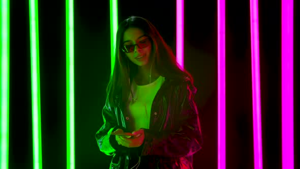 Portrait of a Pretty Young Beautiful Woman in Stylish Sunglasses Is Dancing and Enjoying Music From