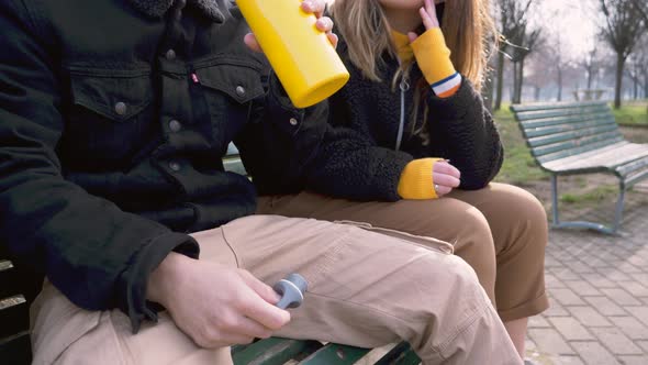 Slow motion shot of young man drinking from yellow thermos bottle