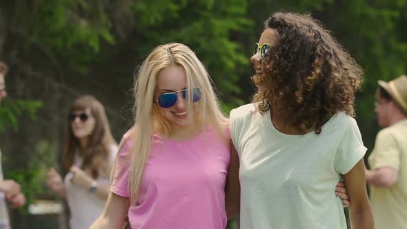 Excited Female Friends Hugging and Dancing Together, Having Fun at Outdoor Party