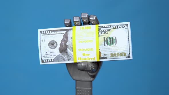 A Mechanical Hand Holds a Pack of Dollars. A Gray Cyborg Hand Holds Money on a Blue Background.