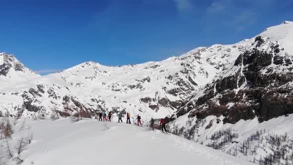 Group of ski touring on skin uphill in a line. Ski touring in big mountains