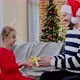 Father gives a Christmas gift to his daughter dressed in festive red dress - VideoHive Item for Sale