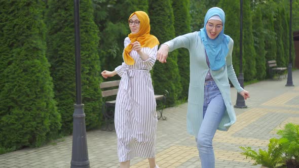 Two Positive Muslim Young Women Dancing in the Park