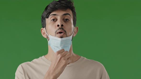 Exhausted Arab Brunet Man Indian Hispanic Guy Stands Isolated in Green Studio Takes Off Respiratory