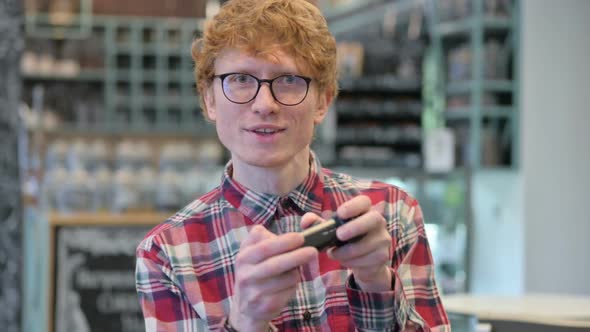 Young Redhead Man with Video Game Controller Playing