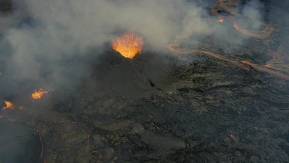 Aerial view around magma bursting out through a hole in the ground - circling, drone shot