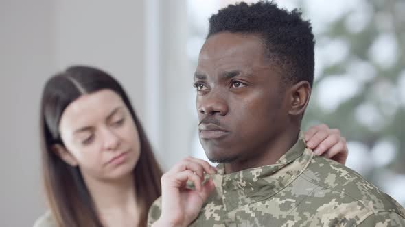 Closeup Portrait of Thoughtful African American Military Man Looking Away As Blurred Caucasian Young