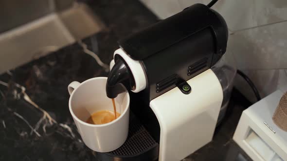 Coffee is Poured Into a Mug From a Coffee Machine