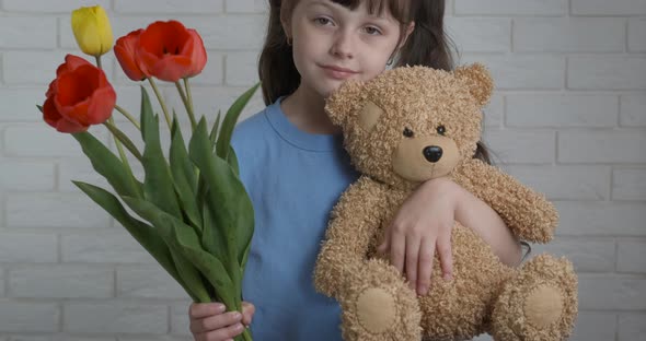 Little Girl with a Teddy Bear and Flowers