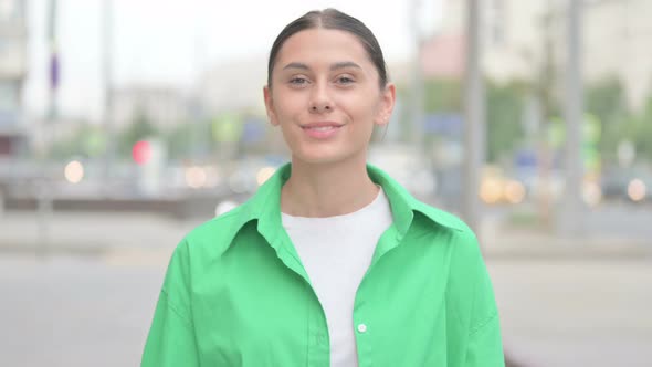 Thumbs Up By Hispanic Woman Standing Outdoor