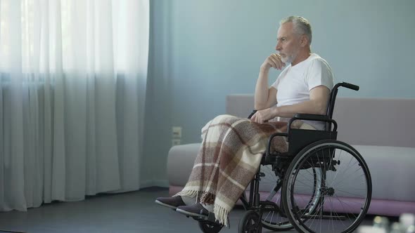 Elderly Man in Wheelchair Deciding to Move Forward, Strong Will for Recovery