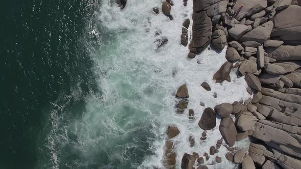 View From a Drone Vertically Down on a Stone Cape Washed By Strong Waves