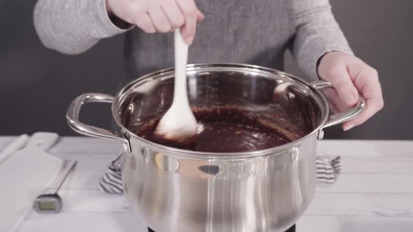 Step by step. Mixing ingredients in the cooking pot to make simple chocolate fudge.