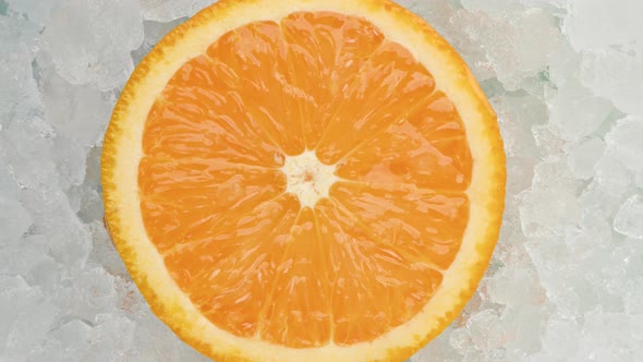 Slice of orange rotating over ice 