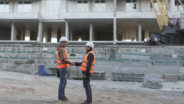 Two construction professionals discussing a construction work plan at a construction site.