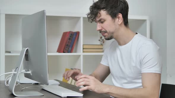 Angry Young Creative Man Upset While Working on Desktop