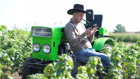 Rural Guy Farmer Uses a Smartphone