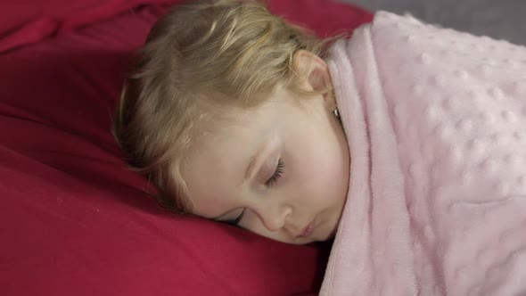 Cute Baby Sleeping on the Bed at Home. Little Girl Sleeping in Morning Light