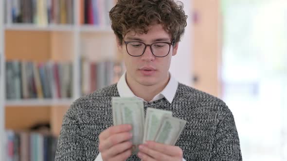 Portrait of Happy Young Man Counting Dollars