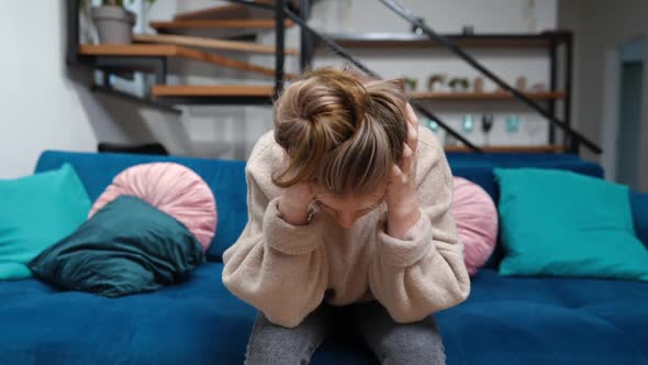 Stressed Depressed Teenage Girl Holding Head in Hands and Looking at Camera with Sad Facial