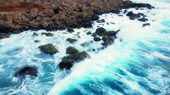 Ocean Coastline Cliffside with Blue Pure Water Sea Waves Washes the Rocky Shore Above Aerial Shot