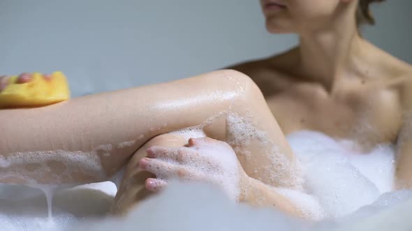 Beautiful Girl in Bath Washing Legs With Sponge, Beauty Procedure, Skin Care