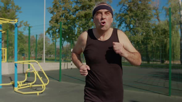 Elderly Man Doing Exercise. Senior Man Running in Park. Health Lifestyle and Exercise Concept.