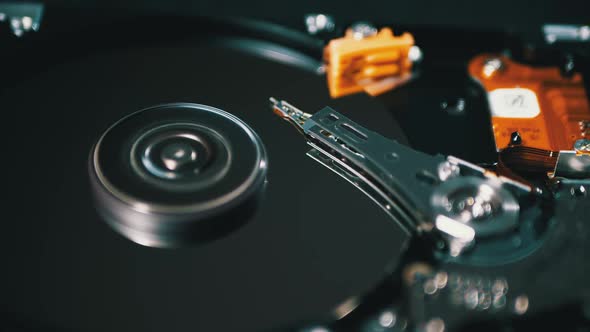 Opened Hard Disk Drive with Spinning Platter. Move of Writing Magnetic Head