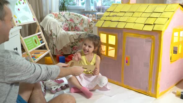 Father Gives Happy Little Girl a Key To Her New Cardboard House.