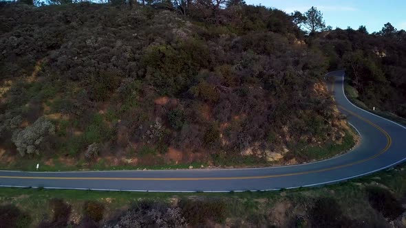 Tight Curve of Mountain Road beside Steep Cliff at Dawn, Drone Reveal