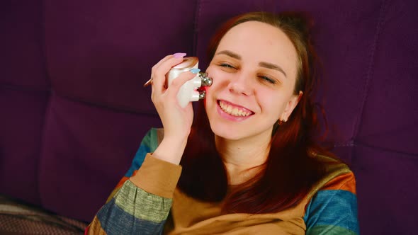 Cheerful Woman Using Face Massager