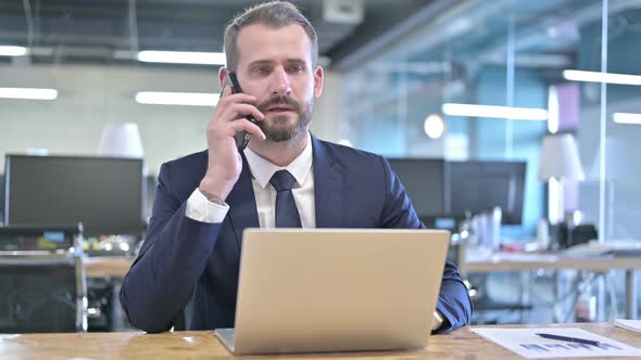 Ambitious Young Businessman Talking on Smartphone