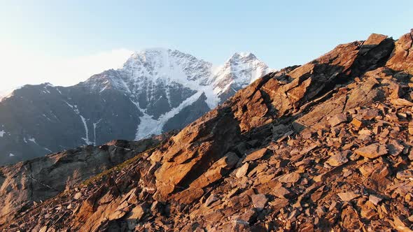 Bare Rocky Cliffs Against Snowcapped Mountains of Elbrus