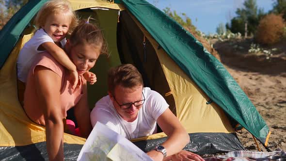 A Happy and Friendly Family Makes a Plan for the Route of Travel on a Paper Map