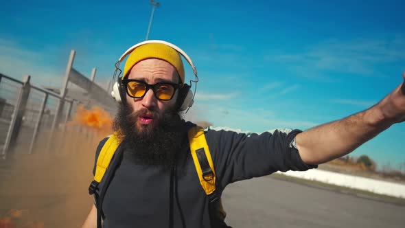 Portrait of a Hipster in Yellow Glasses. Dancing Street Dance with Orange Smoke. Slow Motion