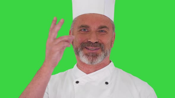 Elderly Professional Chef Man Showing Delicious Gesture To Camera on a Green Screen Chroma Key
